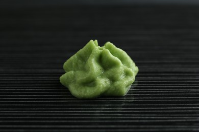 Photo of Hot wasabi paste on black textured table, closeup