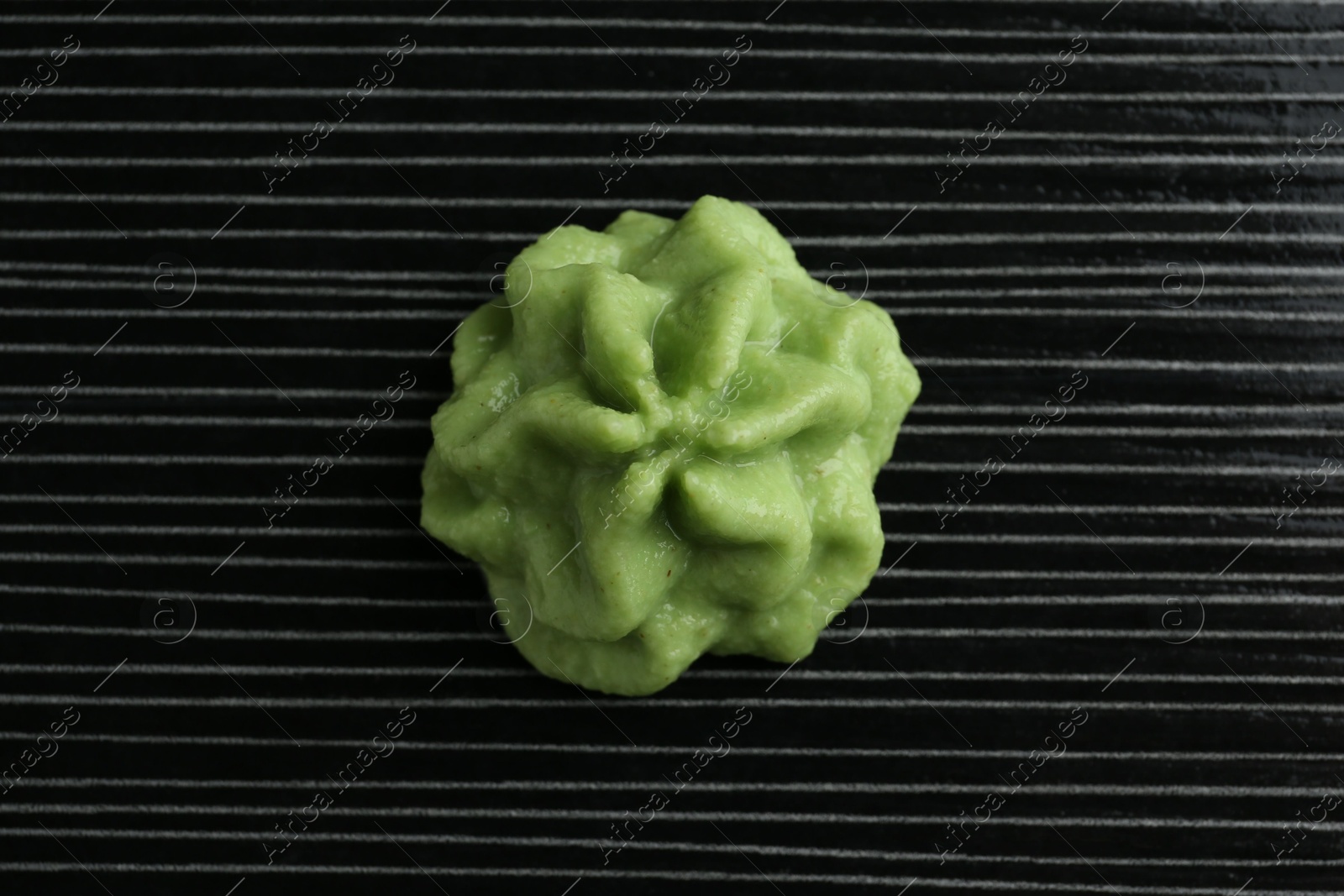 Photo of Hot wasabi paste on black textured table, top view