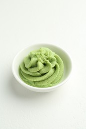 Photo of Hot wasabi paste in bowl on light textured table