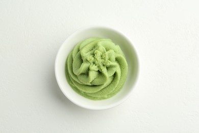 Photo of Hot wasabi paste in bowl on light textured table, top view