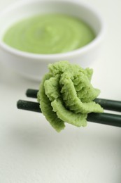 Photo of Chopsticks with hot wasabi paste on light table, closeup