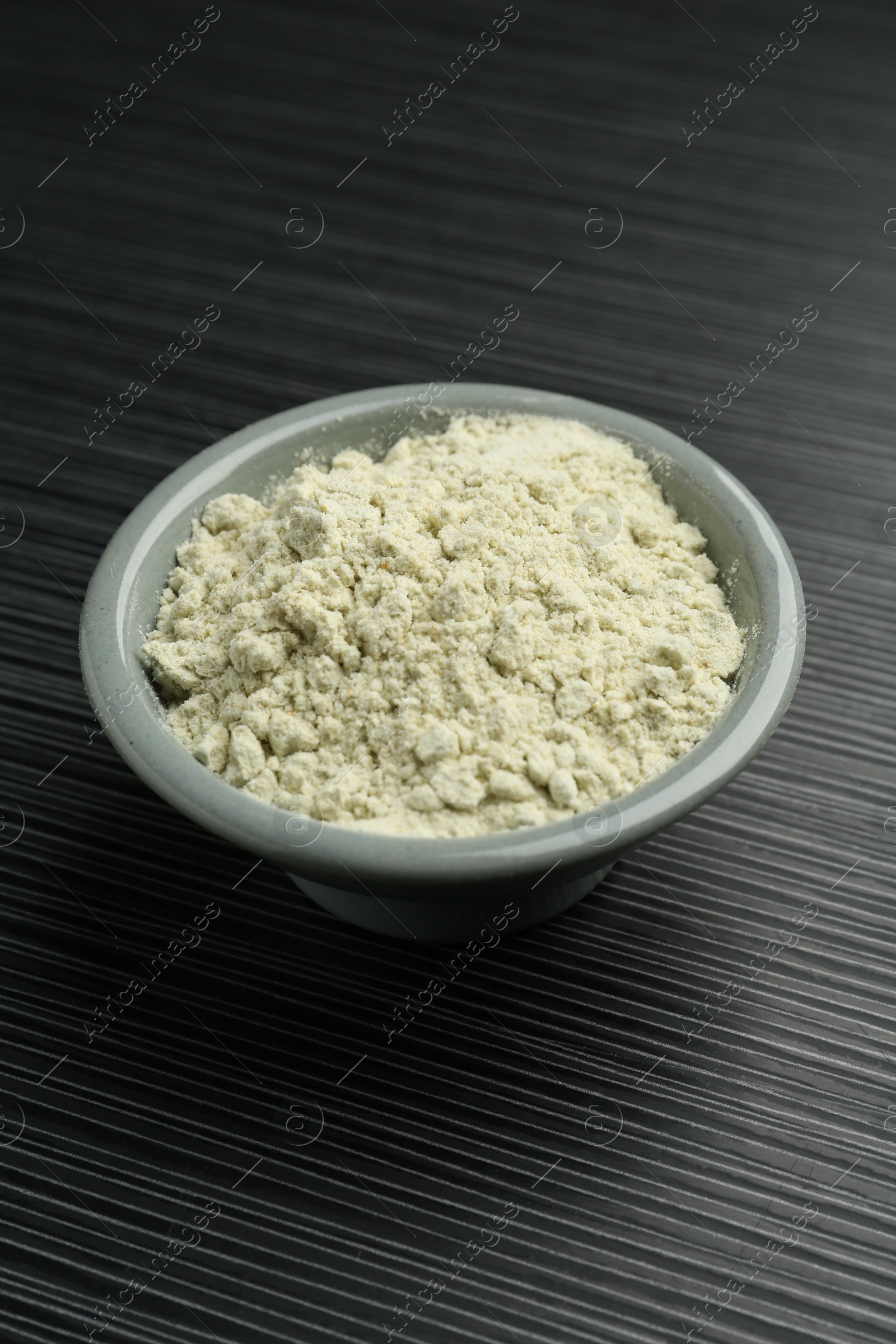 Photo of Wasabi powder in bowl on black textured table