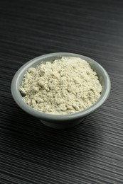 Photo of Wasabi powder in bowl on black textured table