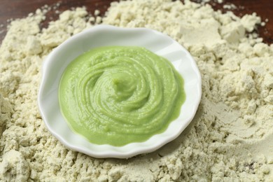 Photo of Bowl with wasabi paste on dry powder, closeup