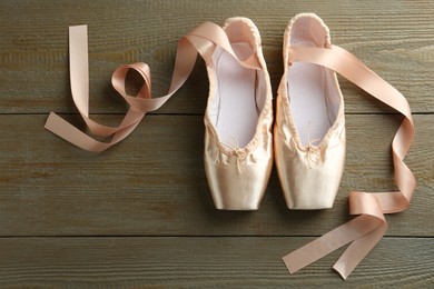 Photo of Pair of beautiful pointe shoes on wooden background, top view