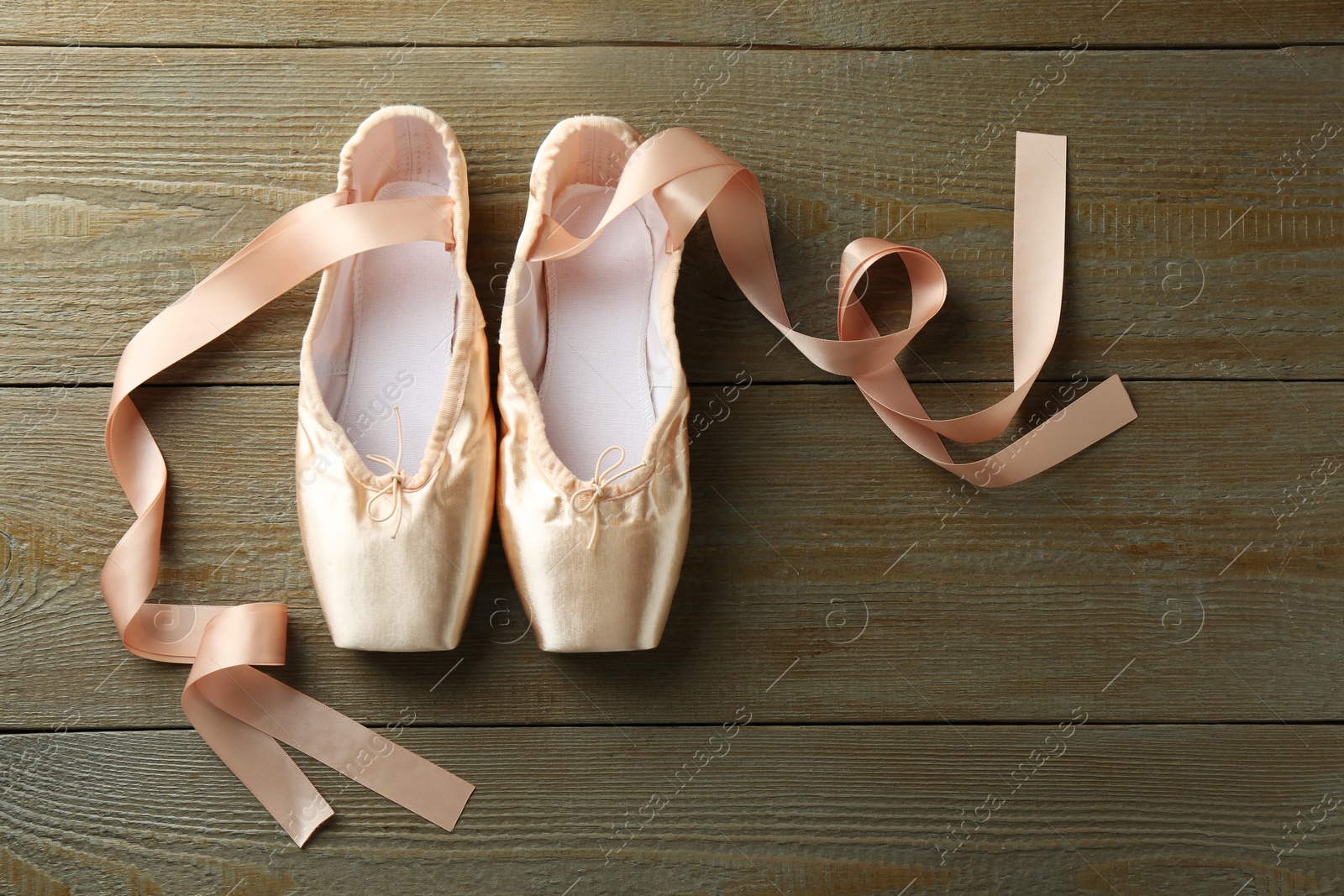 Photo of Pair of beautiful pointe shoes on wooden background, top view