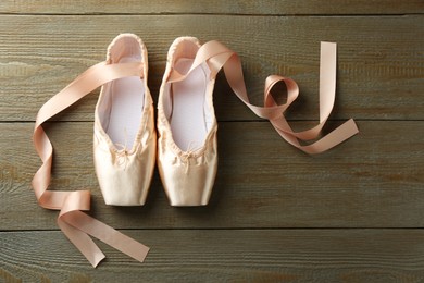 Photo of Pair of beautiful pointe shoes on wooden background, top view