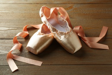 Photo of Pair of beautiful pointe shoes on wooden table