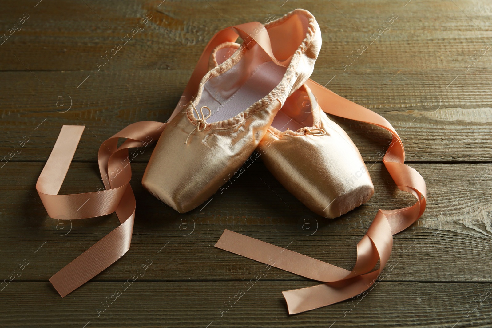 Photo of Pair of beautiful pointe shoes on wooden table