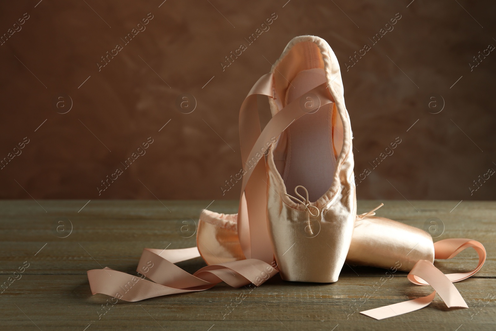 Photo of Pair of beautiful pointe shoes on wooden table