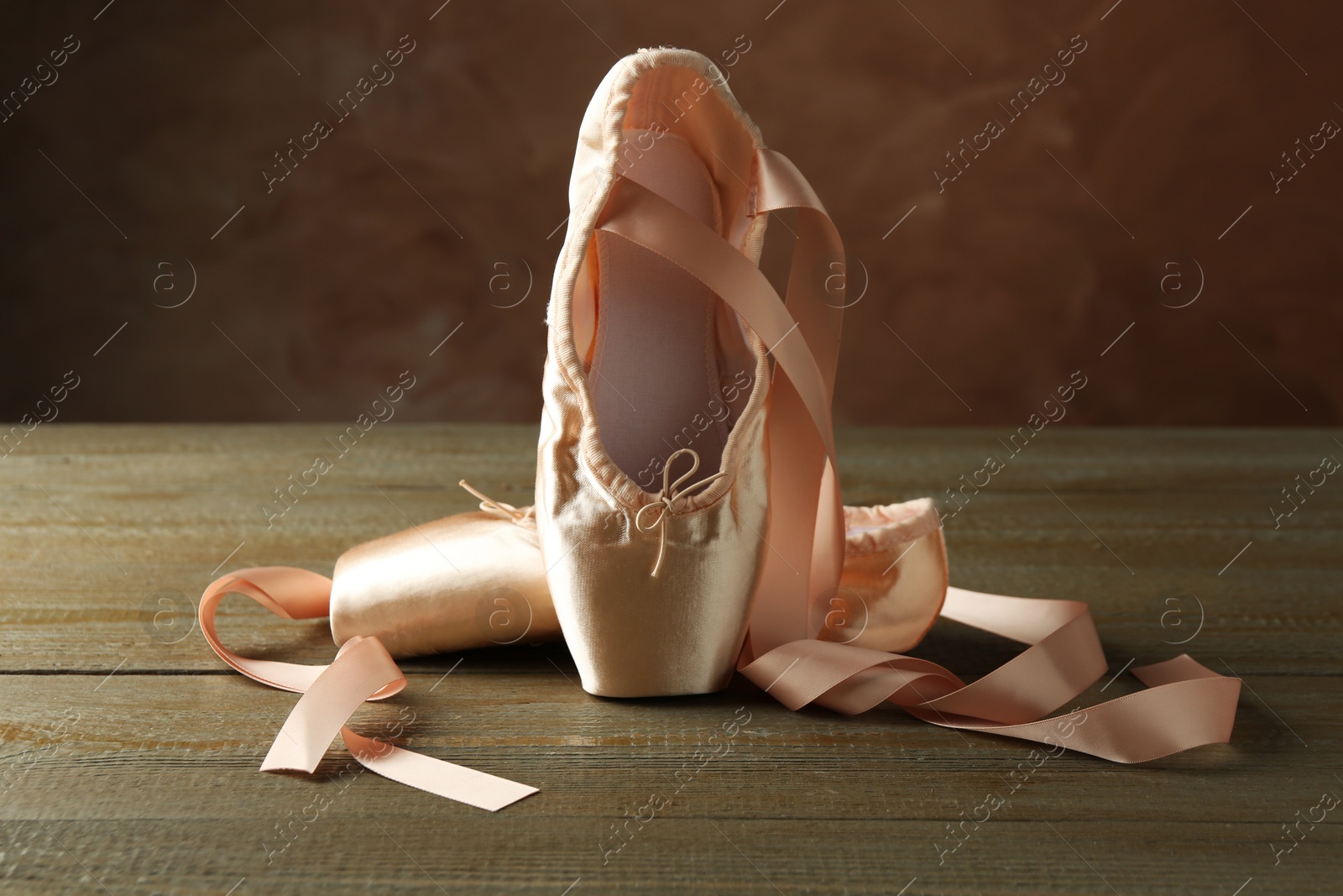 Photo of Pair of beautiful pointe shoes on wooden table