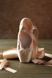 Photo of Pair of beautiful pointe shoes on wooden table