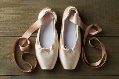 Photo of Pair of beautiful pointe shoes on wooden background, top view