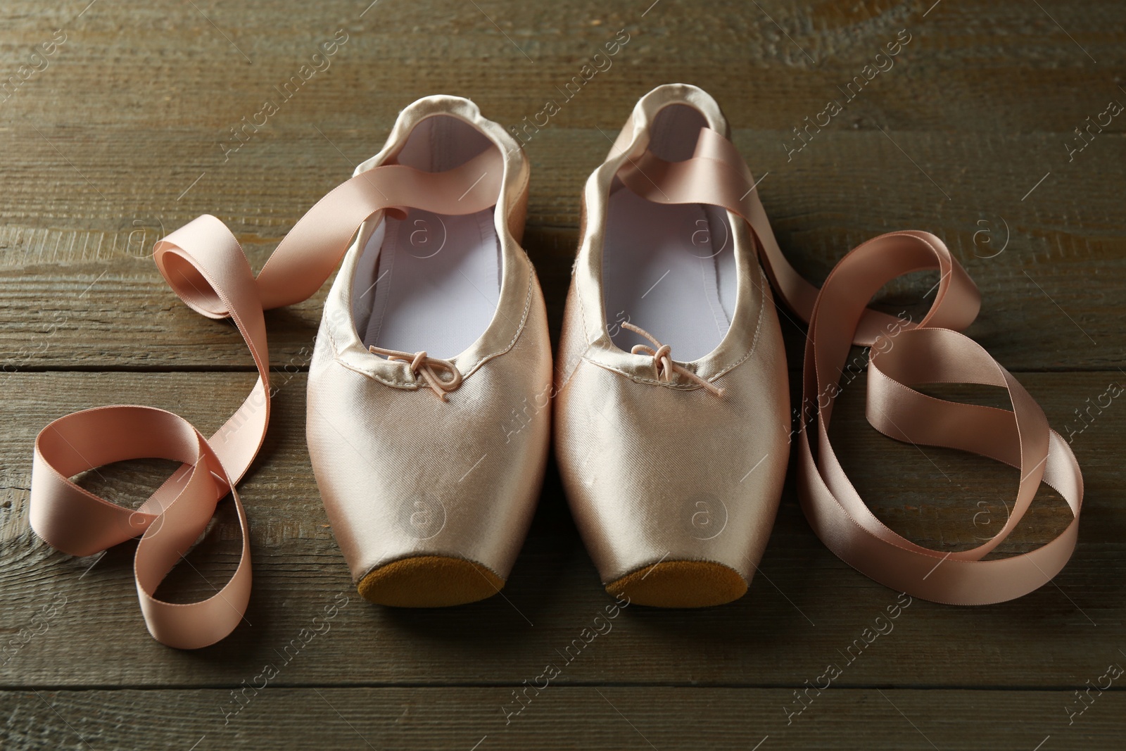 Photo of Pair of beautiful pointe shoes on wooden table