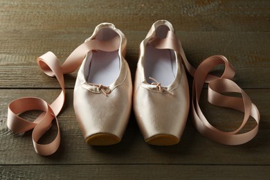 Photo of Pair of beautiful pointe shoes on wooden table