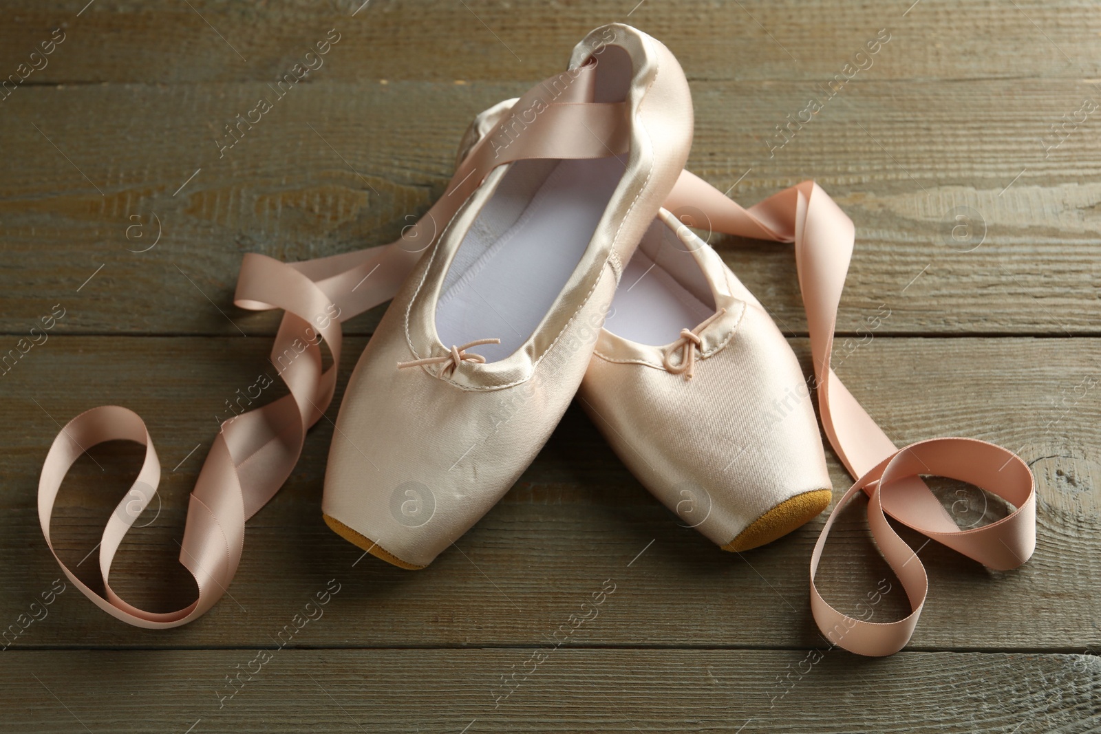 Photo of Pair of beautiful pointe shoes on wooden table