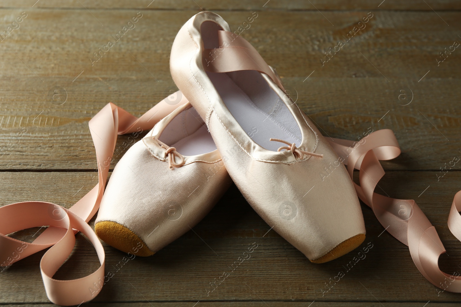 Photo of Pair of beautiful pointe shoes on wooden table