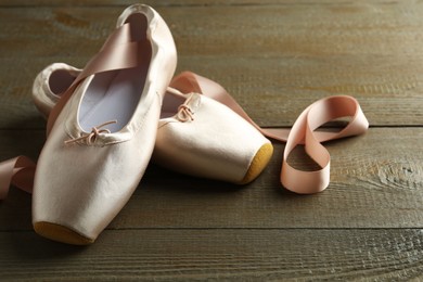 Pair of beautiful pointe shoes on wooden table