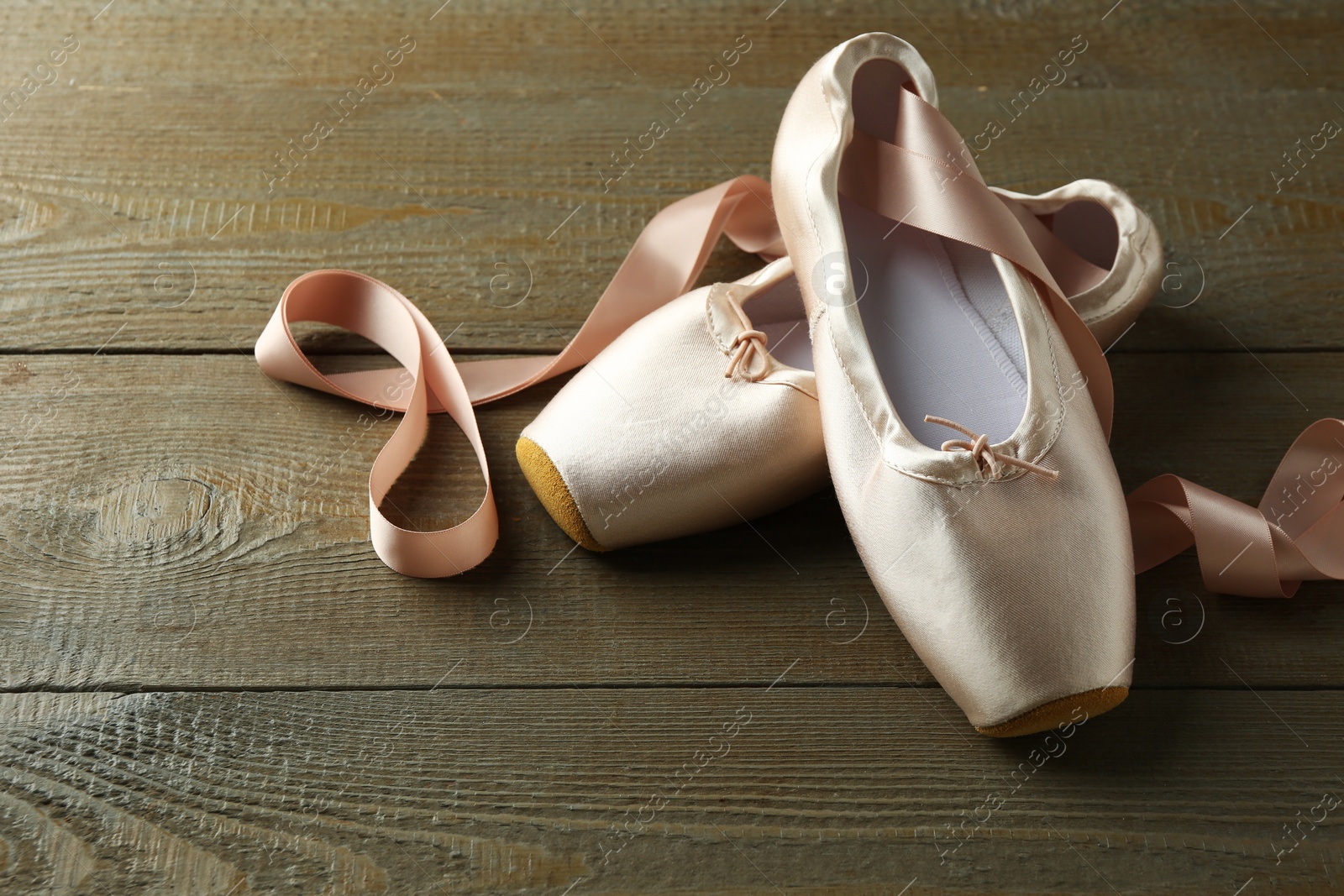 Photo of Pair of beautiful pointe shoes on wooden table