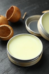 Photo of Natural solid perfume and dry fruit peels on black table, closeup