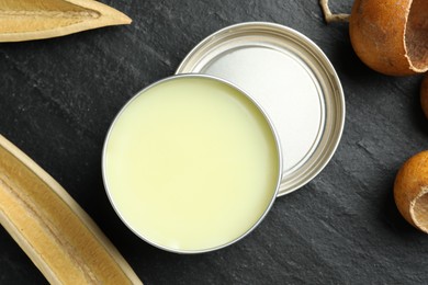 Photo of Natural solid perfume and dry fruit peels on black table, top view