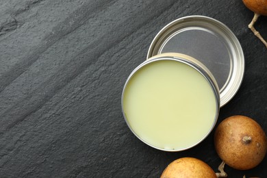 Photo of Natural solid perfume and dry fruit peels on black table, top view. Space for text