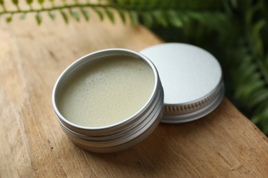 Photo of Natural solid perfume and plant on wood, closeup