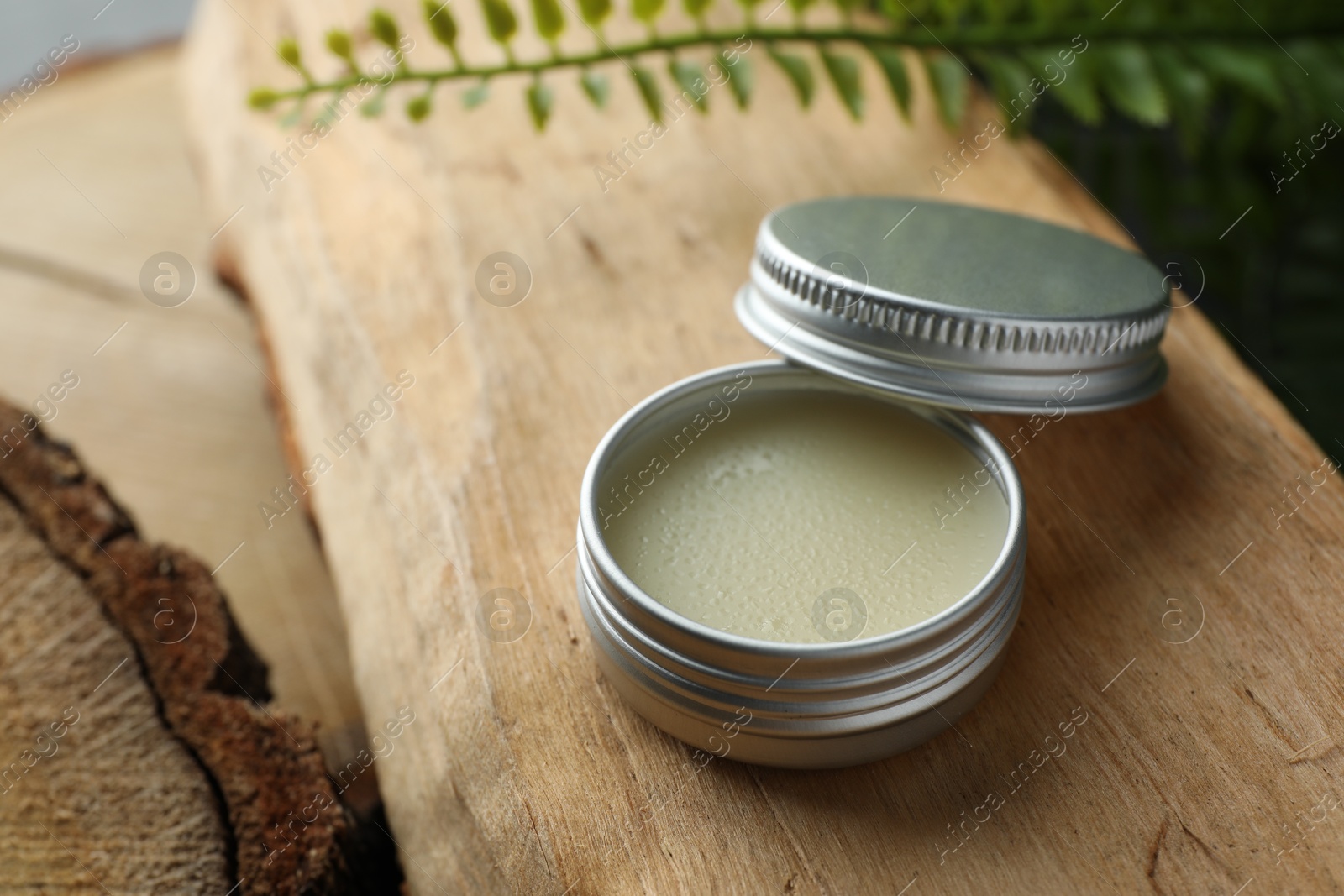 Photo of Natural solid perfume and plant on wood. Space for text