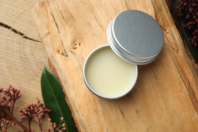 Photo of Natural solid perfume and skimmia plant on wood, top view. Space for text