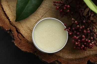 Photo of Natural solid perfume and skimmia plant on wood, top view