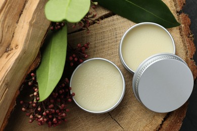 Photo of Natural solid perfume and skimmia plant on wood, top view