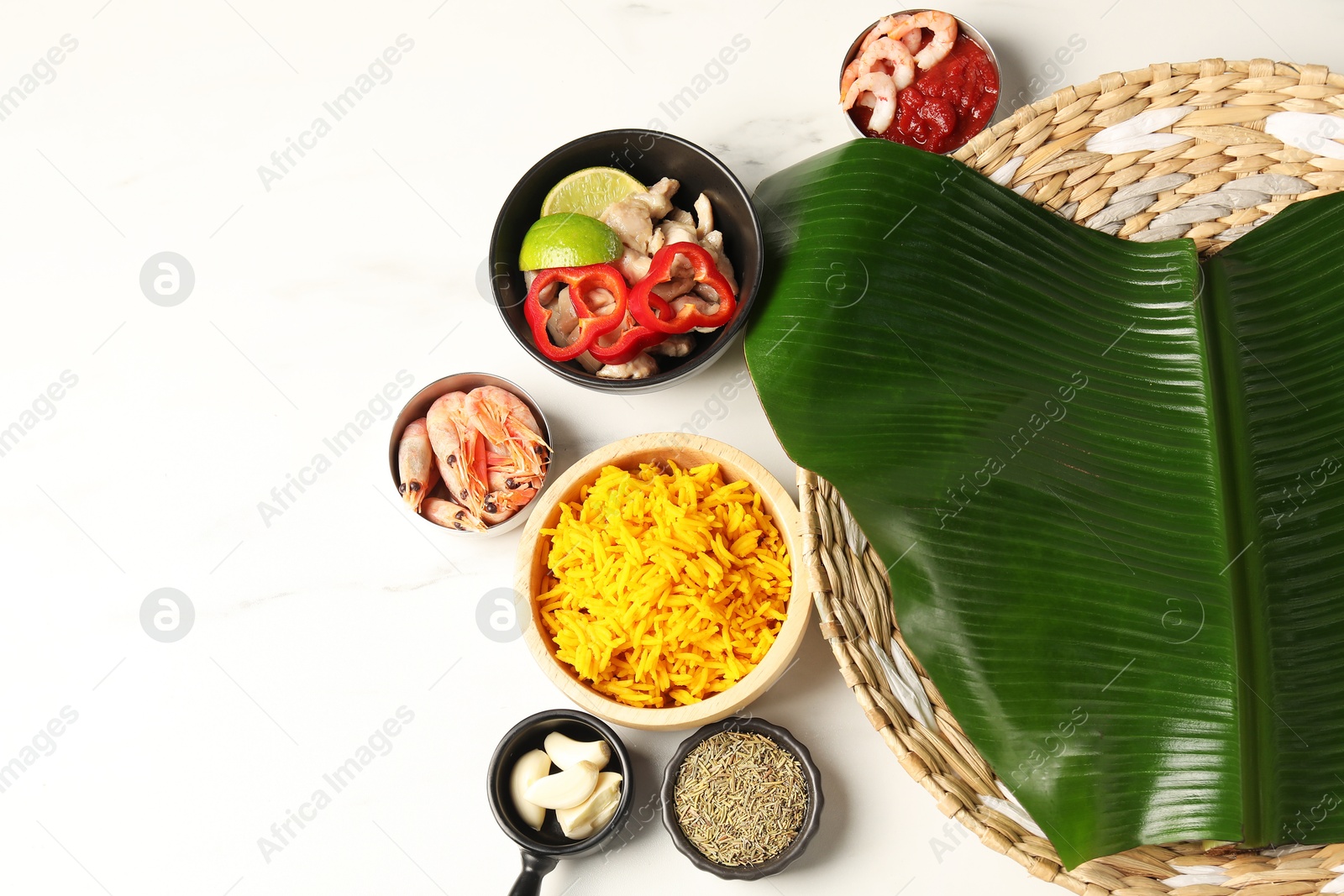 Photo of Piece of banana leaf, different food and spices on white table, flat lay. Space for text