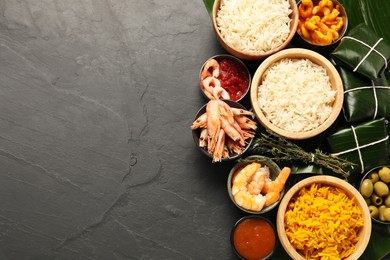 Photo of Cut banana leaves with different food and sauce on dark textured table, flat lay. Space for text