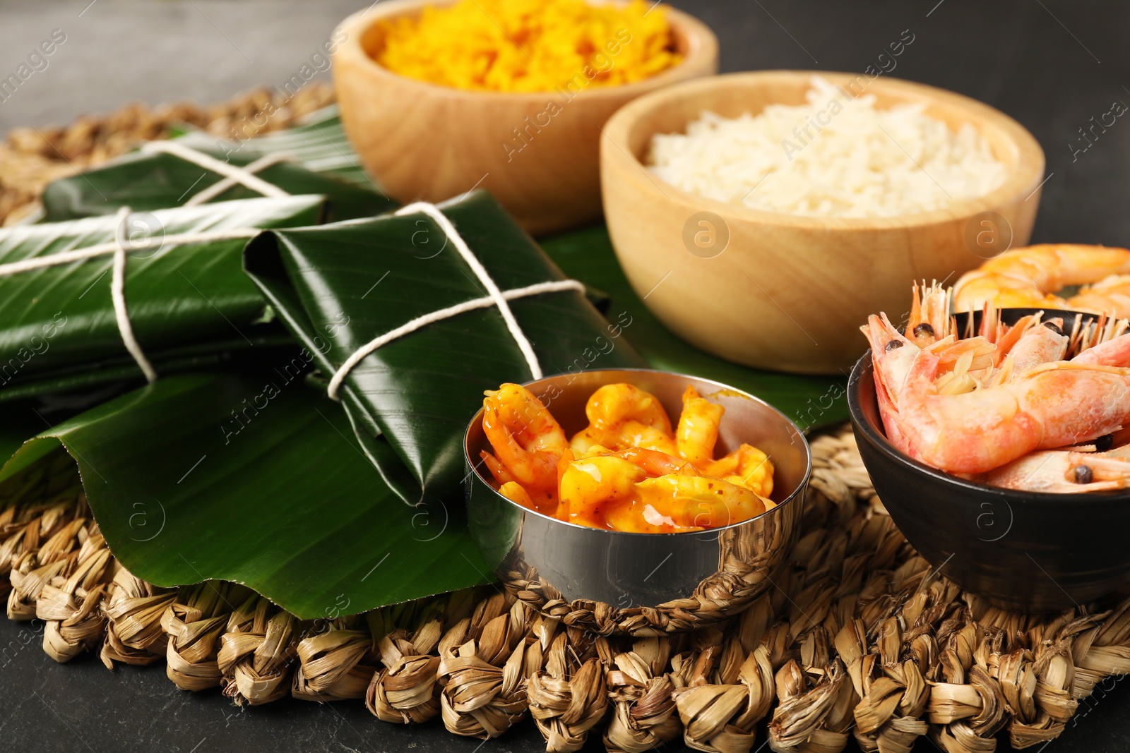 Photo of Cut banana leaves with different food on dark table, closeup. Healthy eco serving