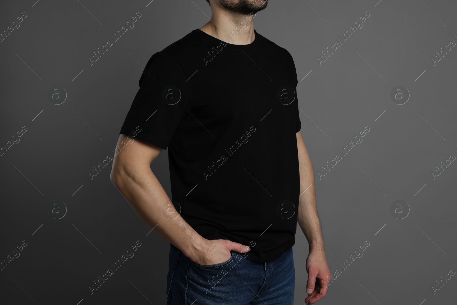 Photo of Man in blank black t-shirt on grey background, closeup. Mockup for design