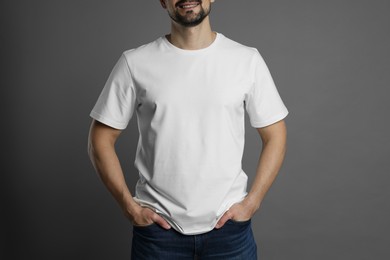 Photo of Man in blank white t-shirt on grey background, closeup. Mockup for design