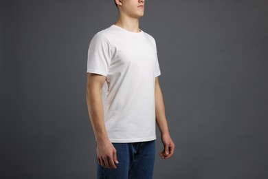 Photo of Man in stylish t-shirt on grey background, closeup. Mockup for design