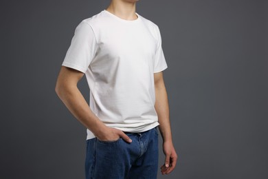 Photo of Man in stylish t-shirt on grey background, closeup. Mockup for design