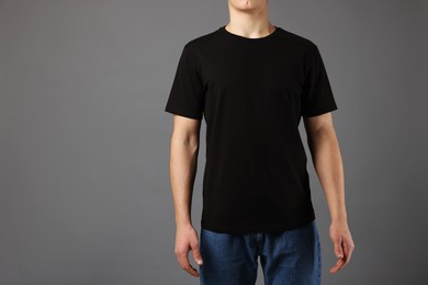 Photo of Man in stylish t-shirt on grey background, closeup. Mockup for design