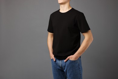 Photo of Man in stylish t-shirt on grey background, closeup. Mockup for design