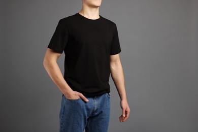 Photo of Man in stylish t-shirt on grey background, closeup. Mockup for design