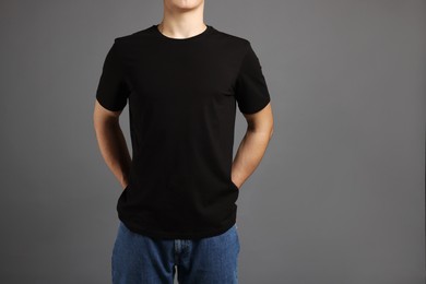 Photo of Man in stylish t-shirt on grey background, closeup. Mockup for design