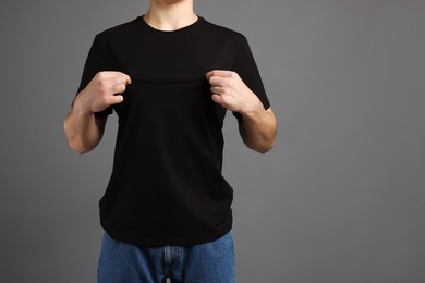 Photo of Man in stylish t-shirt on grey background, closeup. Mockup for design