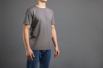 Photo of Man in stylish t-shirt on grey background, closeup. Mockup for design