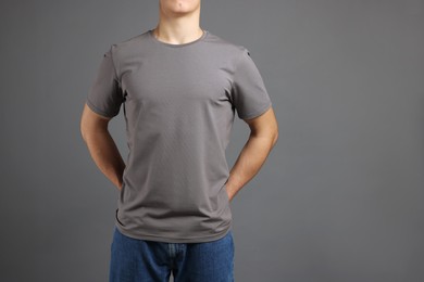 Photo of Man in stylish t-shirt on grey background, closeup. Mockup for design