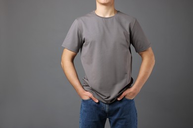 Photo of Man in stylish t-shirt on grey background, closeup. Mockup for design