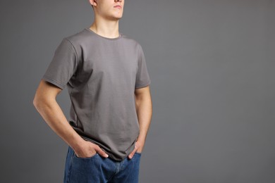 Photo of Man in stylish t-shirt on grey background, closeup. Mockup for design