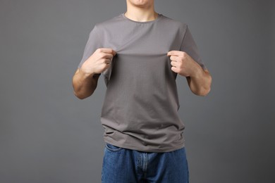 Photo of Man in stylish t-shirt on grey background, closeup. Mockup for design