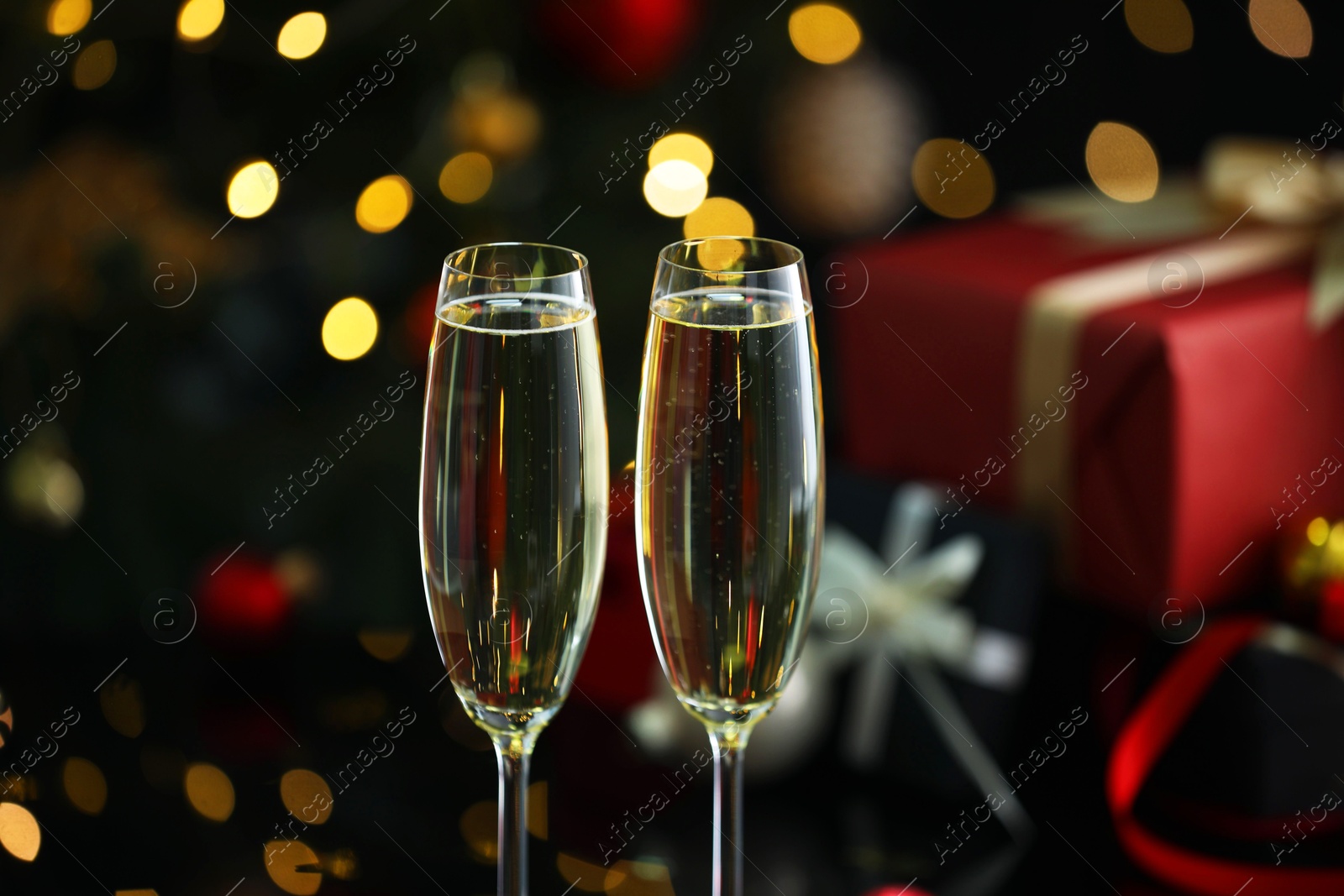 Photo of Delicious champagne in glasses against blurred lights, closeup. Christmas celebration