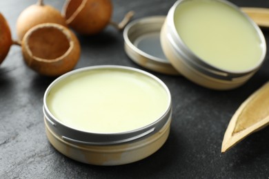 Photo of Natural solid perfume and dry fruit peels on black table, closeup